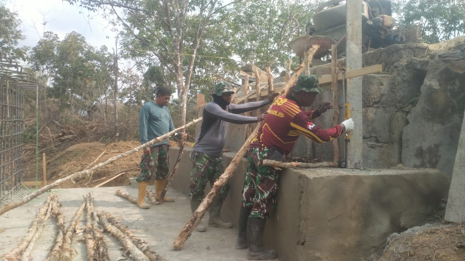 Lantai Dasar Mulai Kering, Satgas TMMD ke-130 Langsung Rakit Tiang Penyangga Jembatan Beton