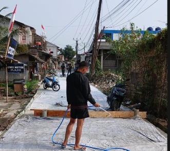 Jaga Kualitas Beton, Satgas TMMD ke-130 Kodim 0510/Tigaraksa Lakukan Penyiraman Jalan
