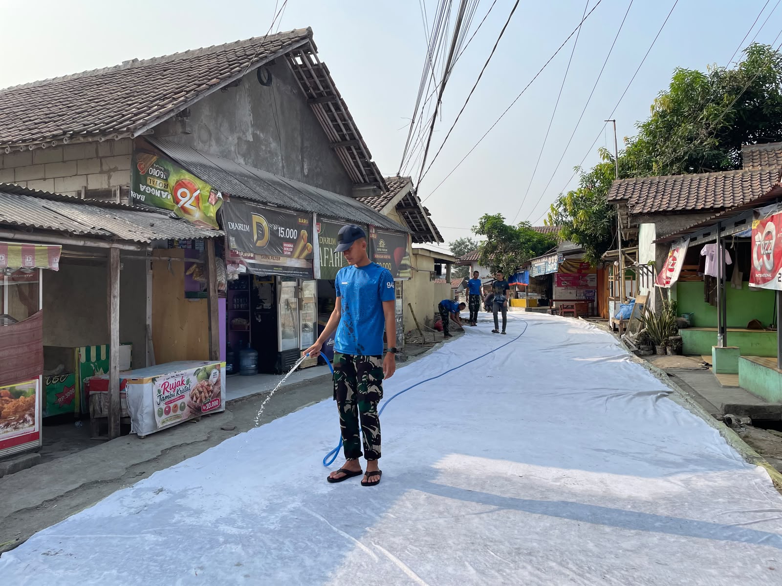 Satgas TMMD ke-130 Kodim 0510/Tigaraksa Laksanakan Penyiraman Jalan Pascapengecoran