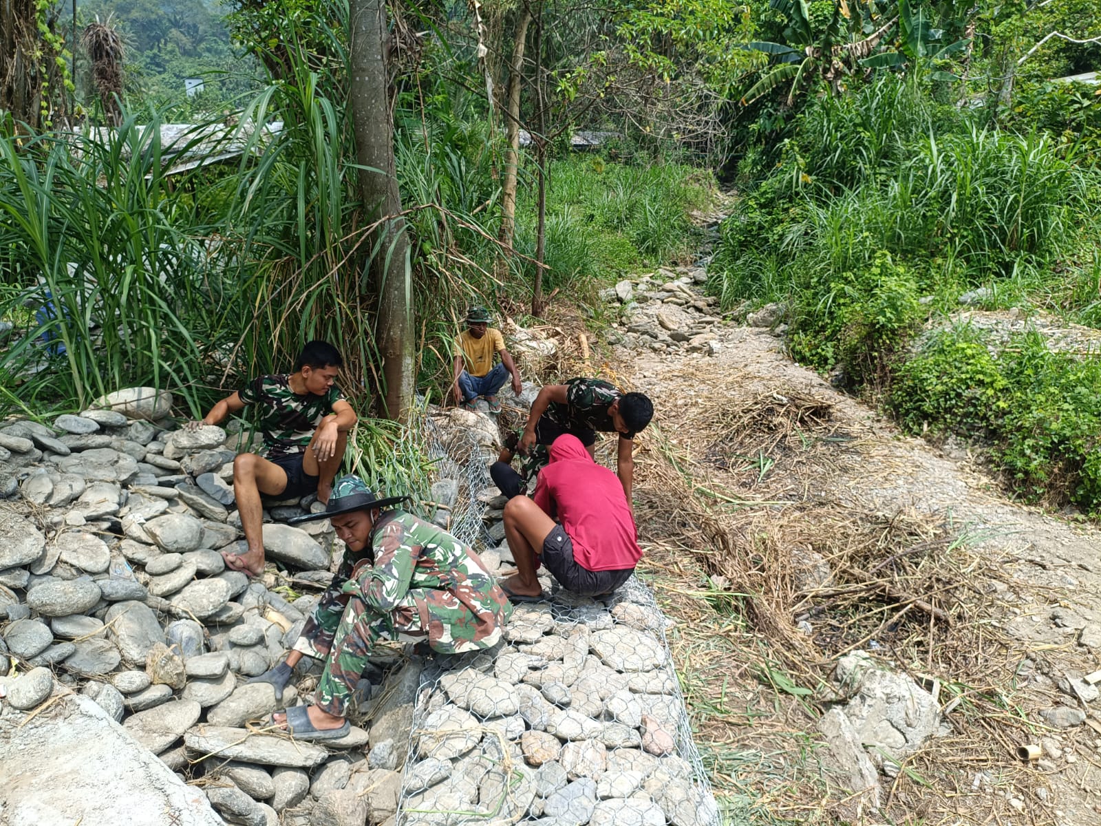 Bukan Sekadar Bangun Jalan, Satgas TMMD Perkuat Tebing Sungai dengan 240 Kubik Batu